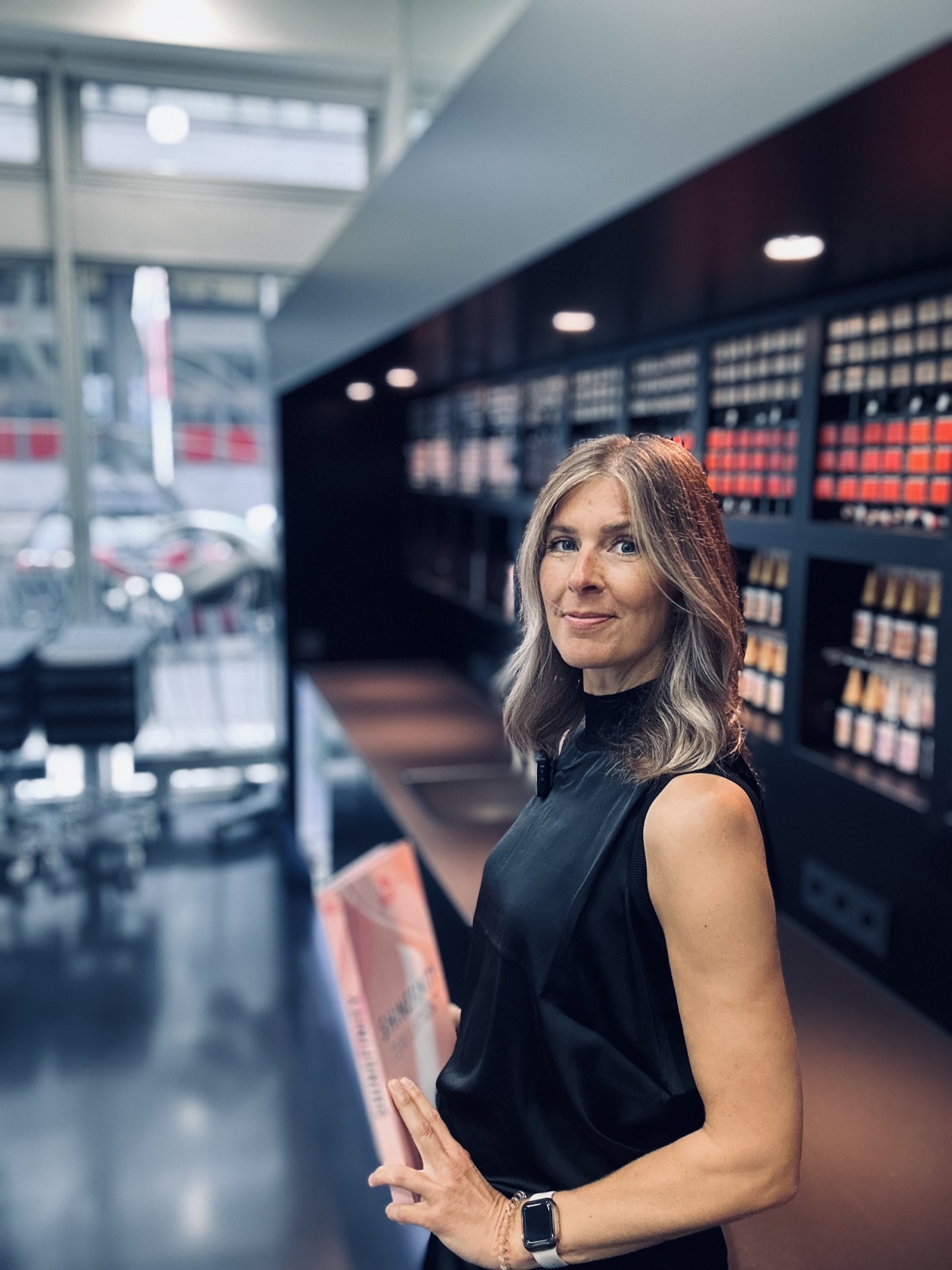 Kerstin Henkens in ihrem Salon, ein Fachbuch in der Hand